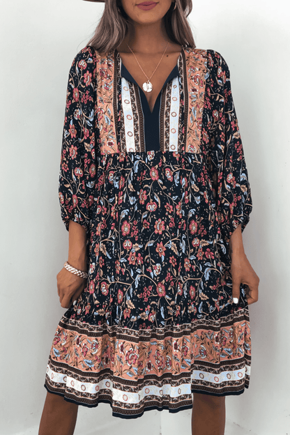 Woman in Navy Floral Border Print Mini Dress - FINAL SALE, with long sleeves and V-neck—perfect for fall.