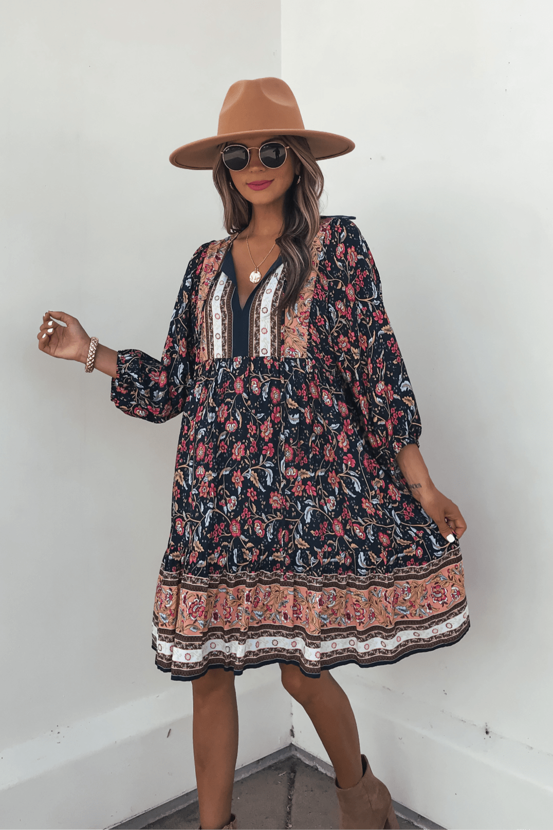 Woman in a Navy Floral Border Print Mini Dress - FINAL SALE, styled with a tan hat and sunglasses for effortless fall fashion.