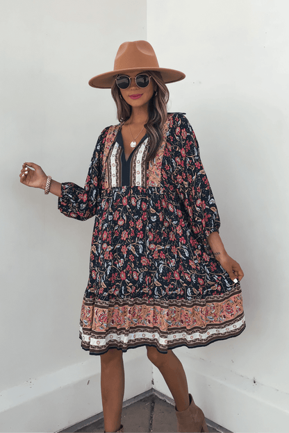 Woman in a Navy Floral Border Print Mini Dress - FINAL SALE, styled with a tan hat and sunglasses for effortless fall fashion.