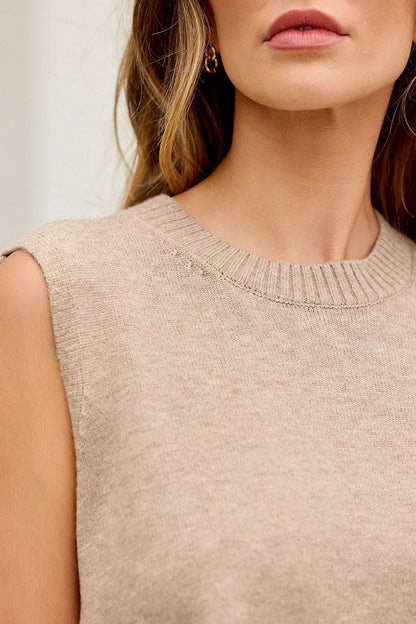 Woman in Nine To Five Cashmere Sweater - Dark Beige, sleeveless, relaxed fit, wavy hair, gold hoop earring; shown shoulder to lips.