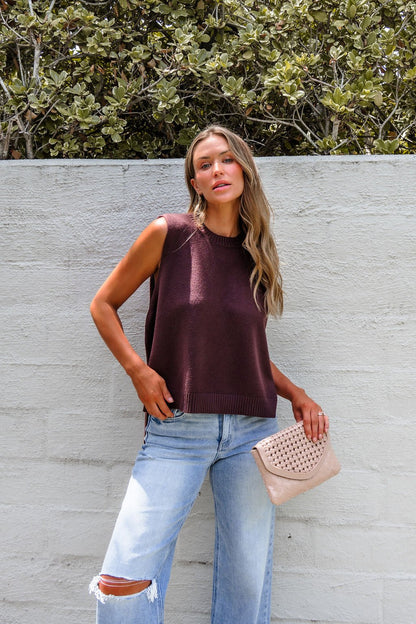 Woman in the Nine To Five Cashmere Sweater - Mocha styles it effortlessly with ripped jeans and a beige clutch for a chic look.