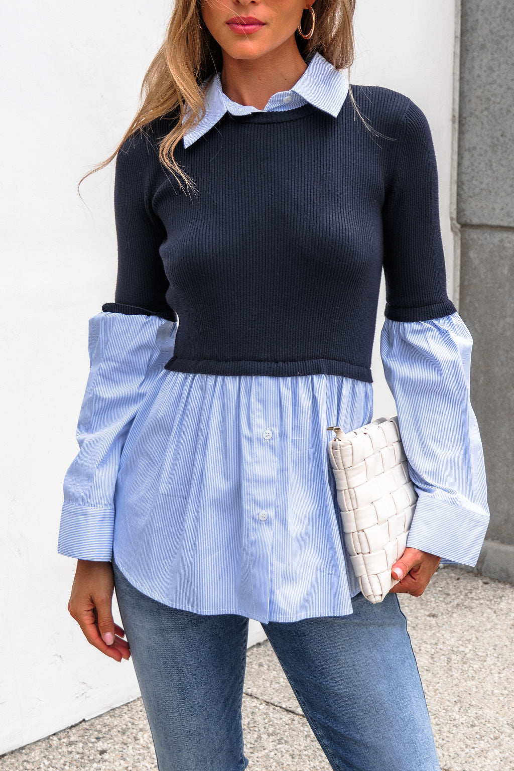 Woman in the Steve Madden Lenny Top - Navy, jeans, and holding a white woven clutch.
