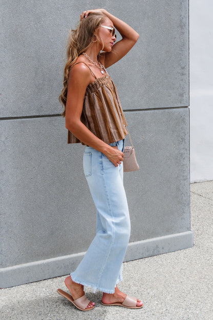 Woman in sunglasses wears Sadie & Sage Striped Linen Cami - Camel, light jeans, and sandals, standing by a gray wall.