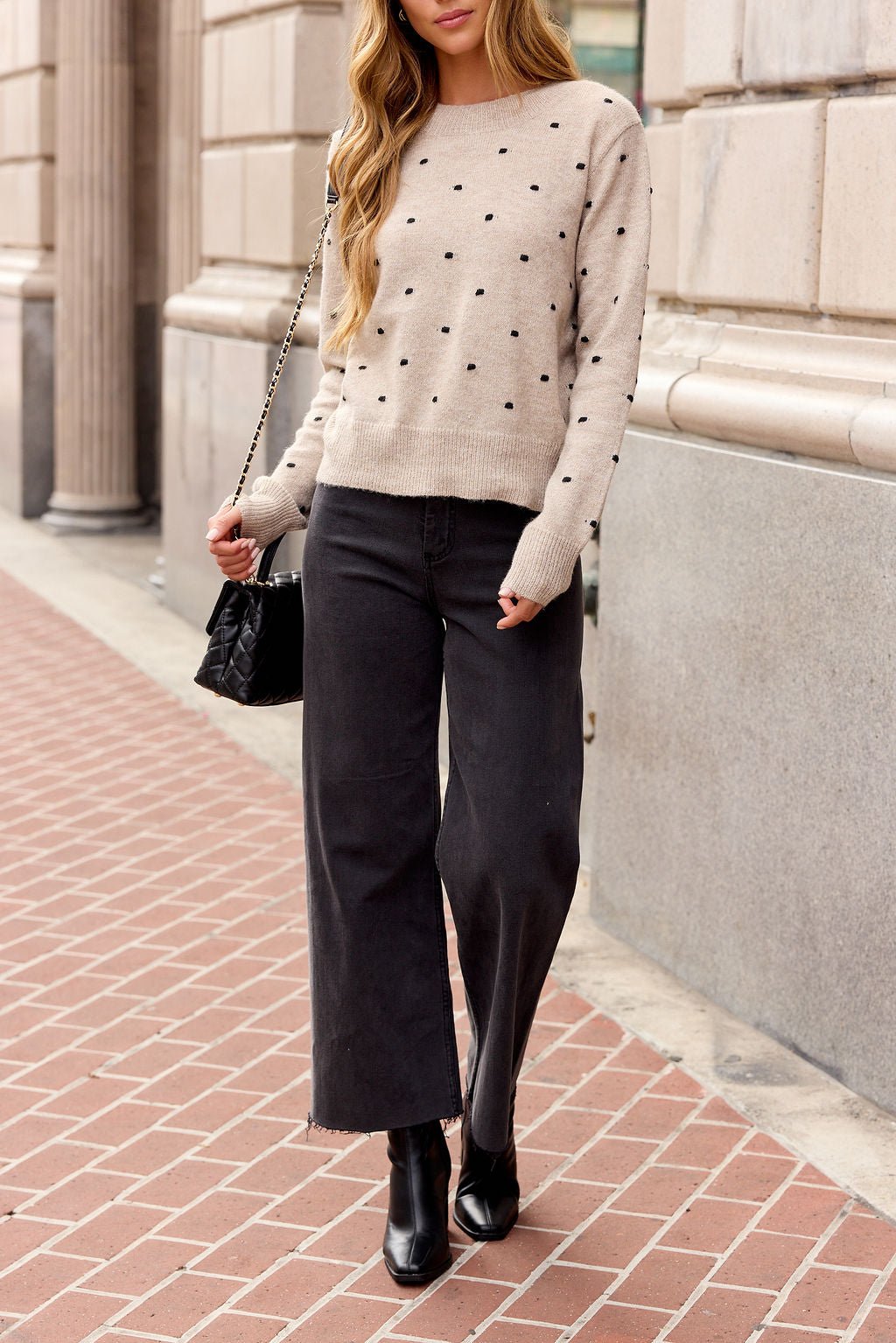 Person in an Oatmeal Ribbed Polka Dot Sweater, black wide-leg jeans, and black boots—ideal for stylish fall layering.