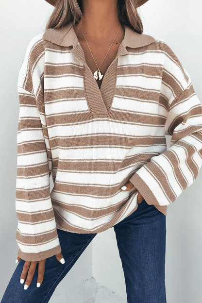 Woman wears an Oatmeal Split V Neck Striped Sweater with blue jeans and a gold necklace, standing against a light background.