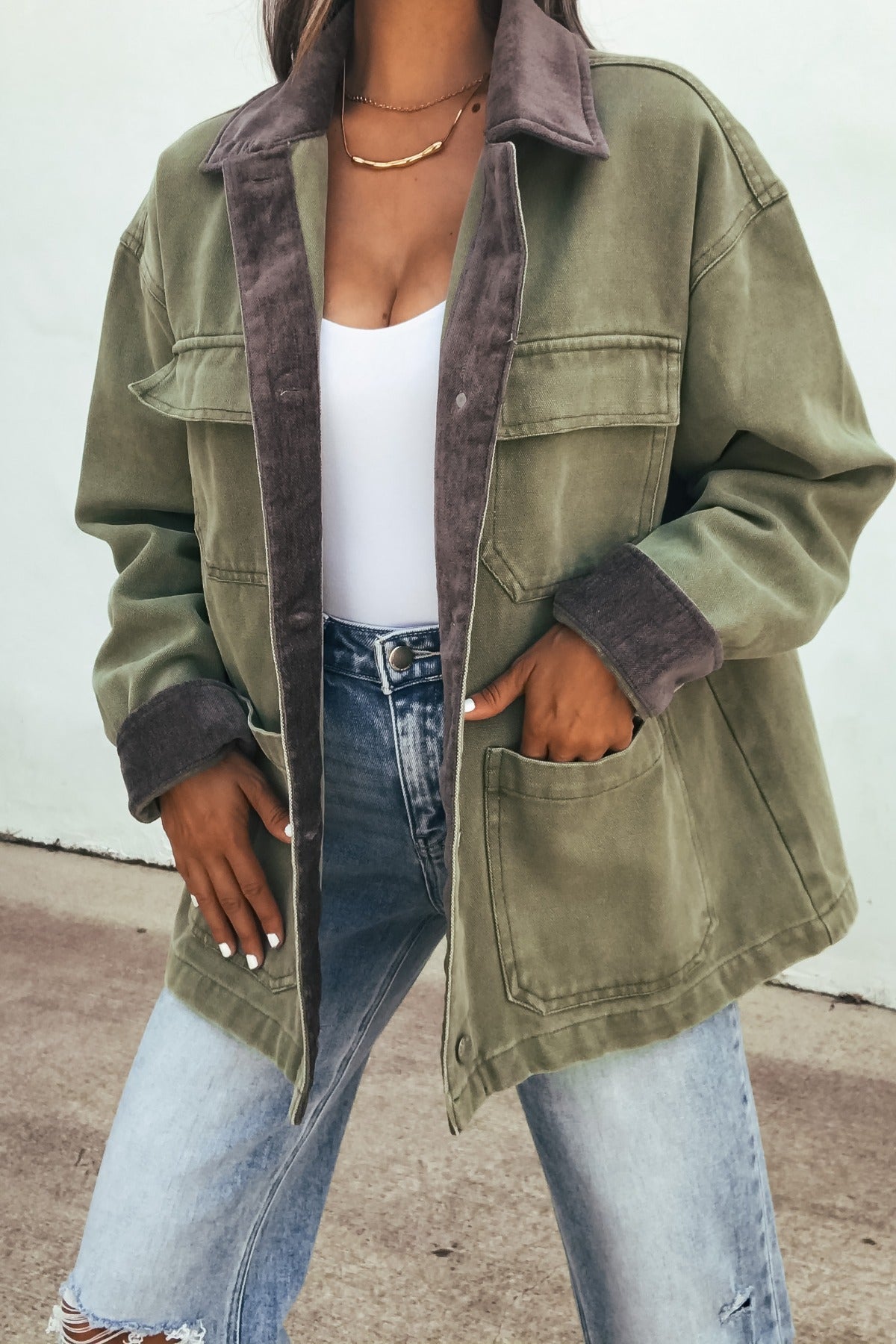 Woman wearing the Olive Contrast Collared Jacket over a white top and ripped jeans, standing outdoors.