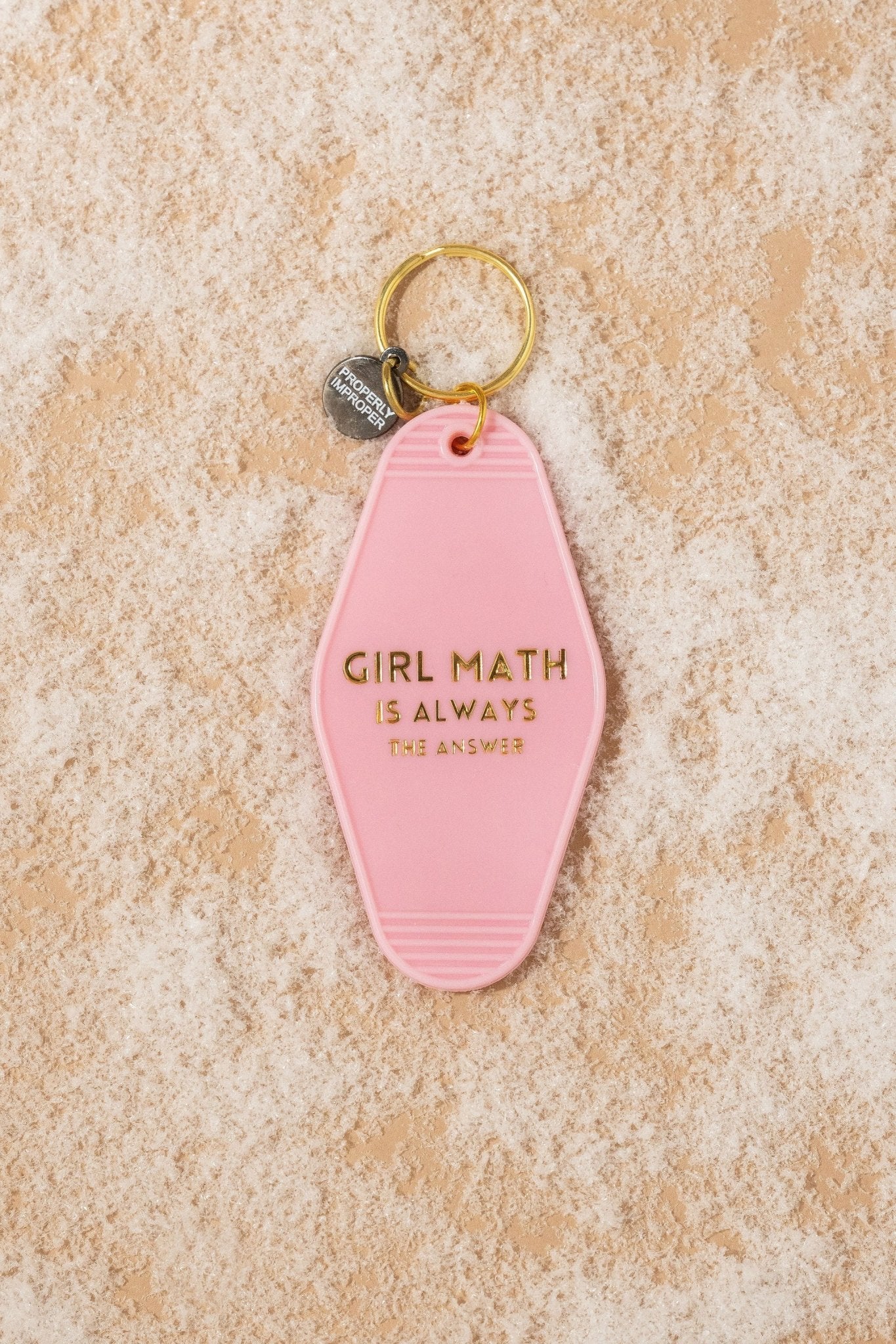 The Pink Girl Math Motel Keychain is a perfect math gift with gold text and retro style on a beige textured surface.