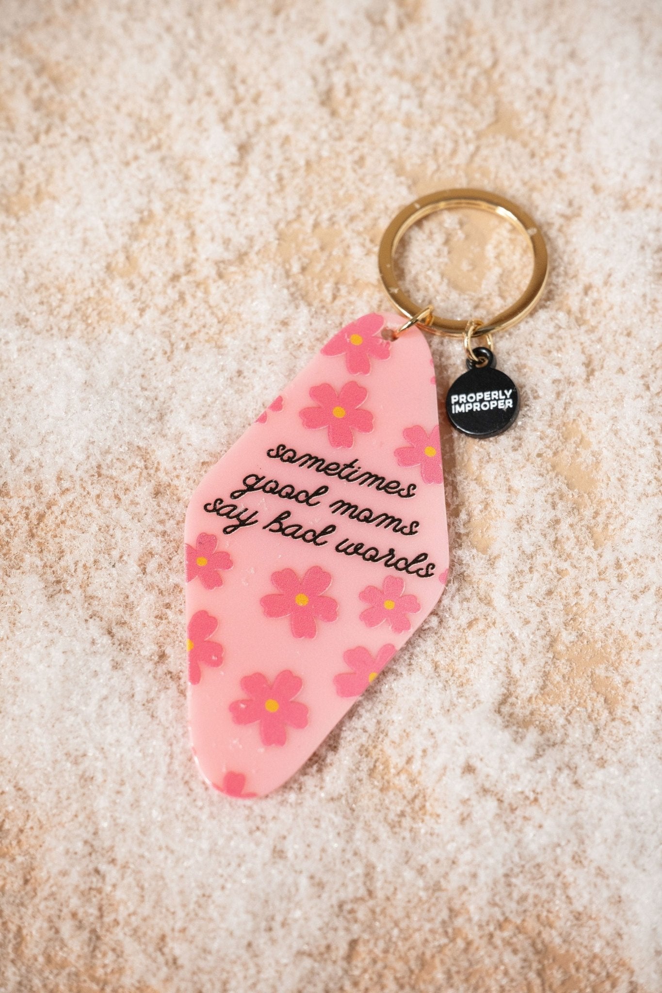 A fun gift, the Pink Sometimes Good Moms Say Bad Words Motel Keychain features a gold keyring and a small black tag.