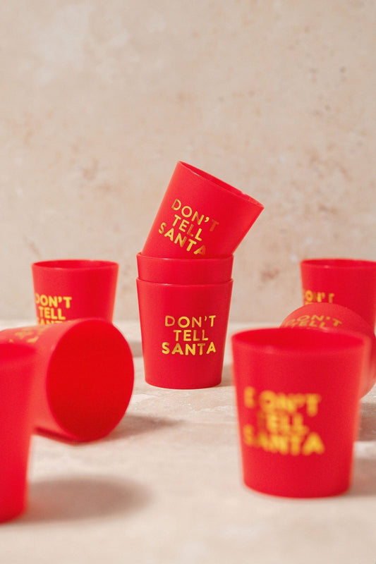 The Red Don't Tell Santa Shot Cup Set includes six festive cups, perfect for holiday parties or as stocking stuffer gifts.