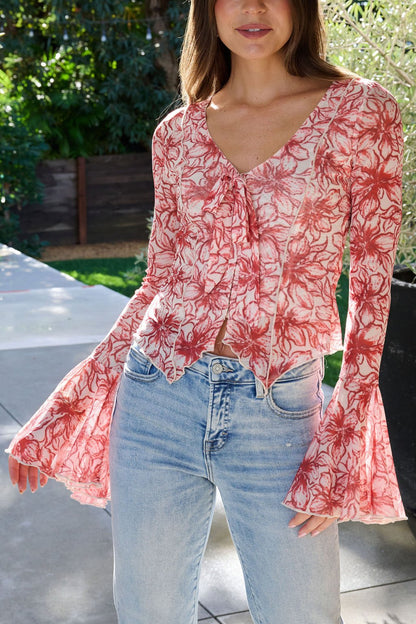 Woman wearing a Red Floral Print Bell Sleeve Mesh Top and light blue jeans, standing outdoors in sunlight.