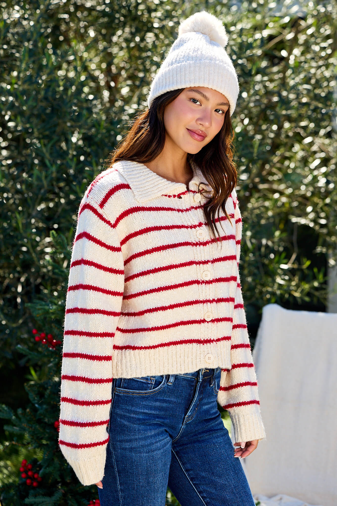 Woman in a Red Striped Button Down Knit Cardigan - FINAL SALE, outdoors with greenery in the background.