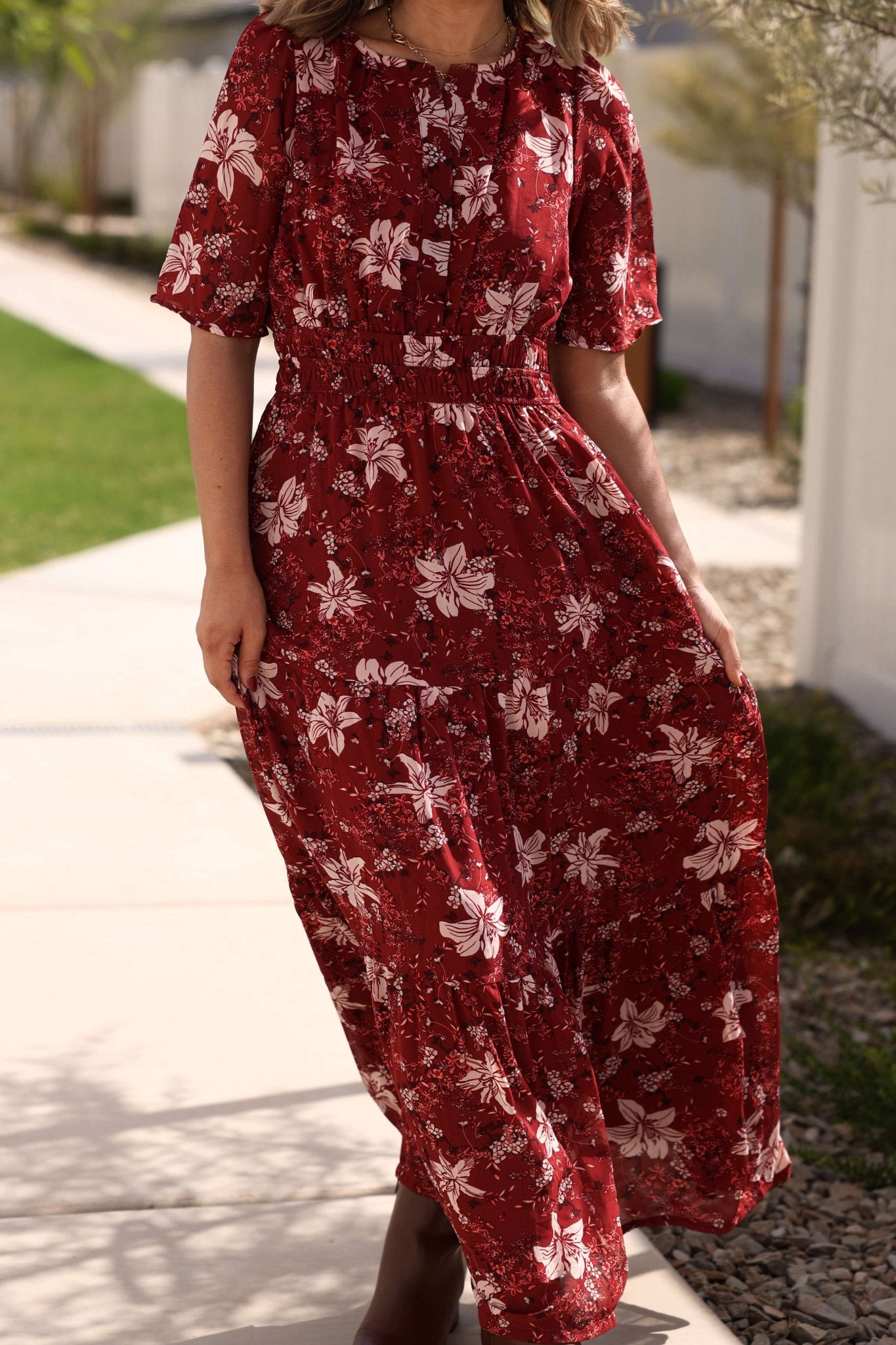 Woman wearing the Rustling Leaves Wine Floral Print Maxi Dress outdoors. Perfect choice for a fall wedding look.