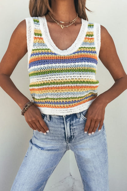 Person wearing a Sadie and Sage Stripe Knit Sweater Tank Top in pastels with light-wash high-waisted jeans.