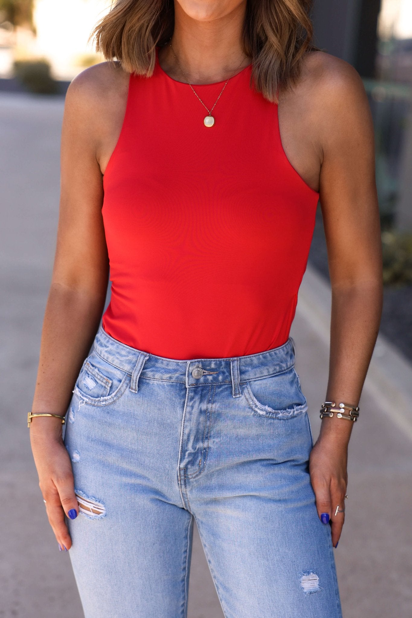 Woman wearing the Sangria Nights Red Tank Bodysuit - DOORBUSTER with light blue high-waisted distressed jeans and accessories.