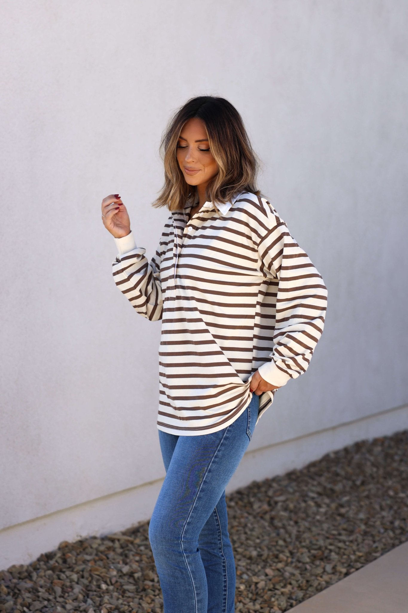 Woman in blue jeans and the Sawyer Brown Striped Pullover - DOORBUSTER stands outdoors, showing effortless fall style.