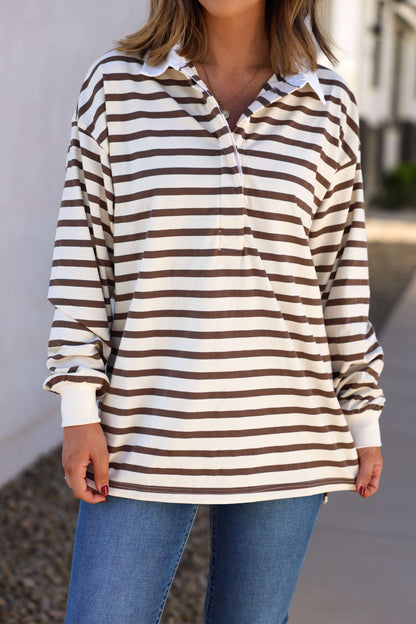 A person wears the Sawyer Brown Striped Pullover - DOORBUSTER with blue jeans outdoors—perfect for fall style.