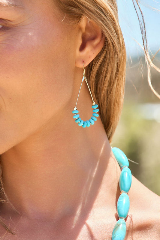 Close-up of a woman wearing Sedona Dangle Earrings - Turquoise, the perfect boho jewelry for any turquoise lover.