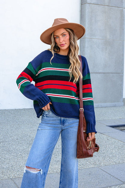 Woman wears a SHE AND SKY ST1207 navy striped sweater outdoors with a wide-brim hat, ripped jeans, and a brown crossbody bag.