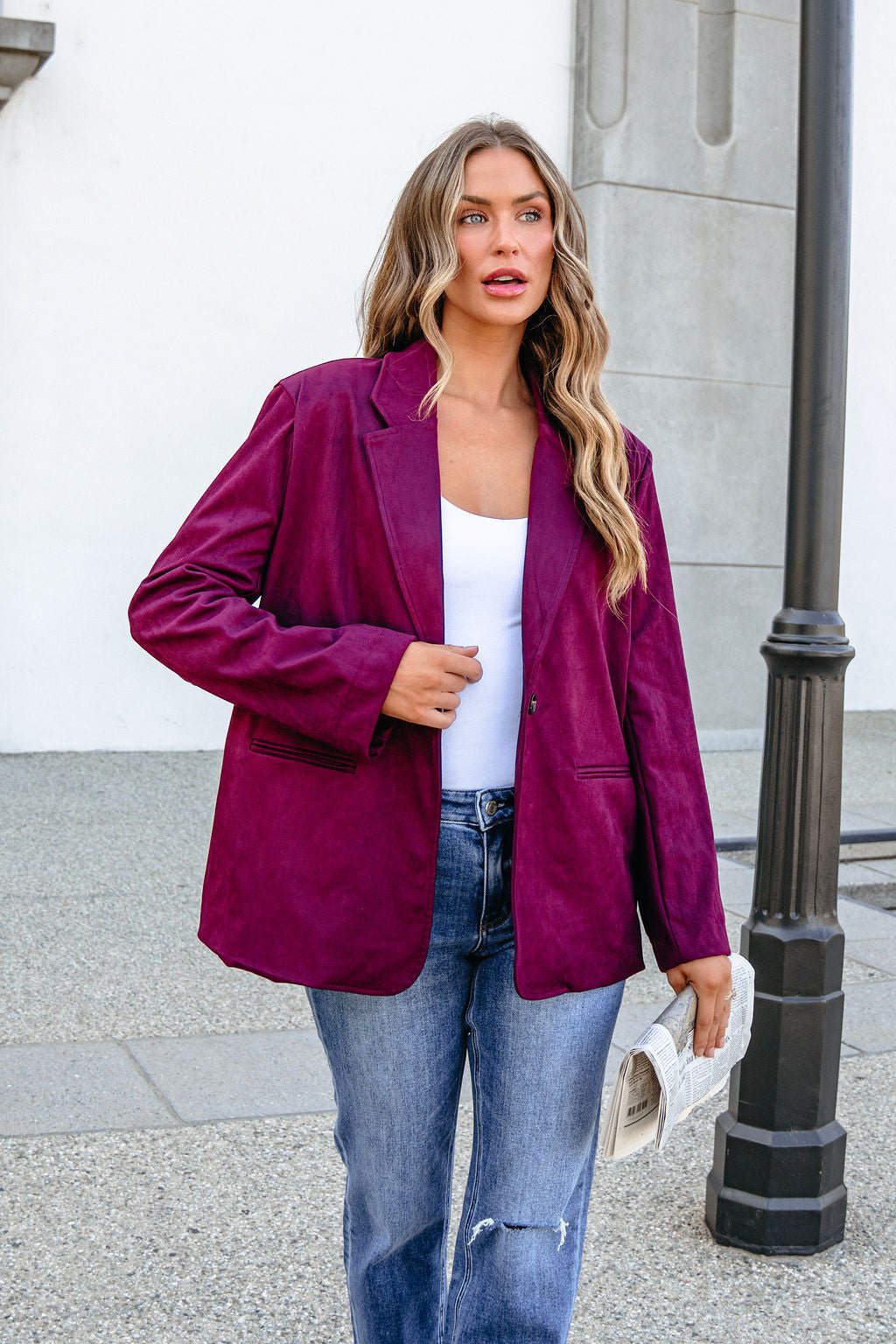 Woman in a SHE AND SKY ST1741 Wine Suede Oversized Blazer holds a white clutch outdoors near a streetlamp.