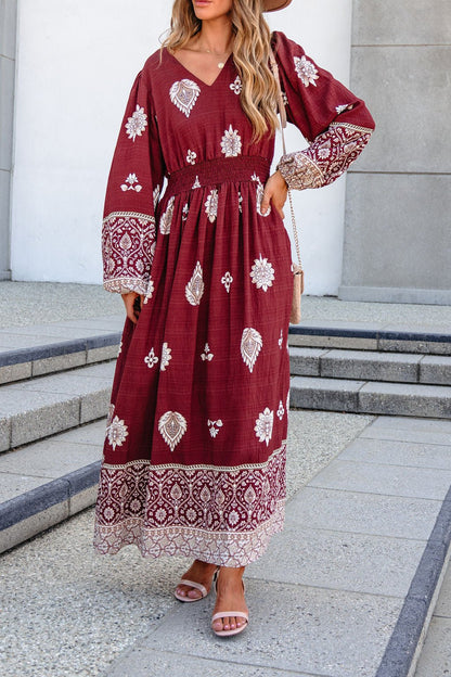 Woman wears the SHE AND SKY ST2144 brown printed long sleeve maxi dress, standing on outdoor steps in sandals.