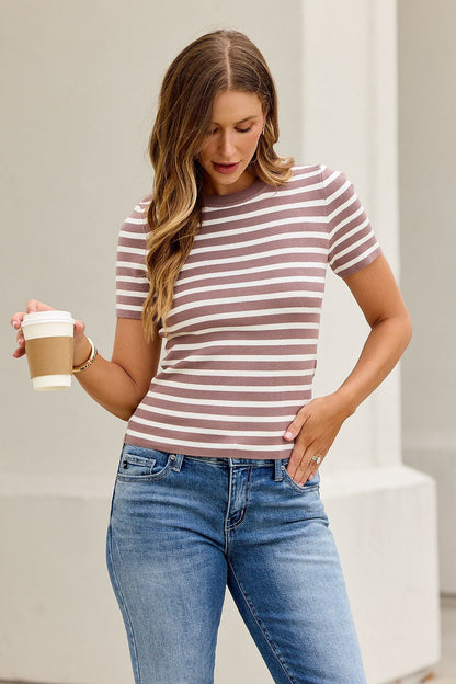 Woman in a slim fit Short Sleeve Striped Sweater Tee - Mocha holds a coffee cup, looking down against a light background.