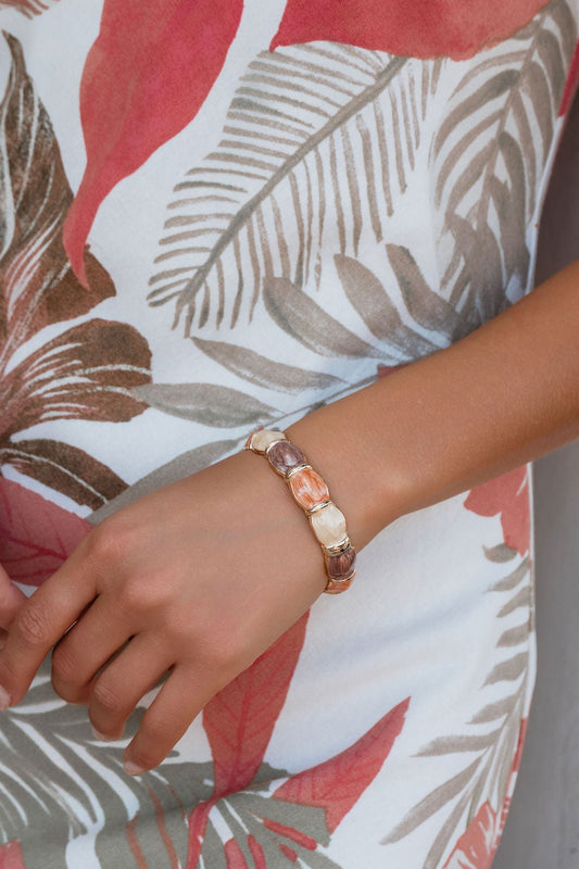 Wearing a colorful leaf-print dress and the Sienna Sunset Stone Bracelet, she radiates a desert-sunset vibe.