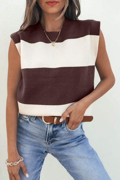 Woman wearing the Sleeveless Brown and Cream Striped Sweater - DOORBUSTER, blue jeans, and accessories, posing with one hand in pocket.