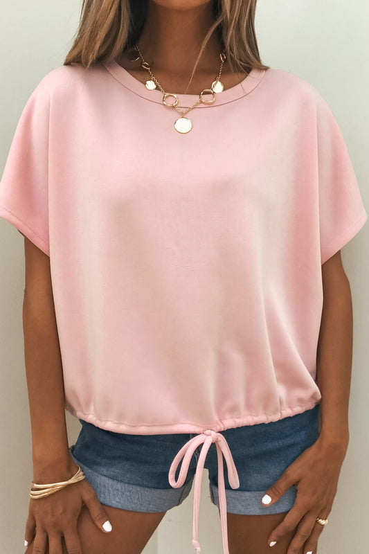 Woman in a Soft Cloud Scuba Lounge Top - Pink, paired with blue denim shorts, gold necklace, and bracelets.