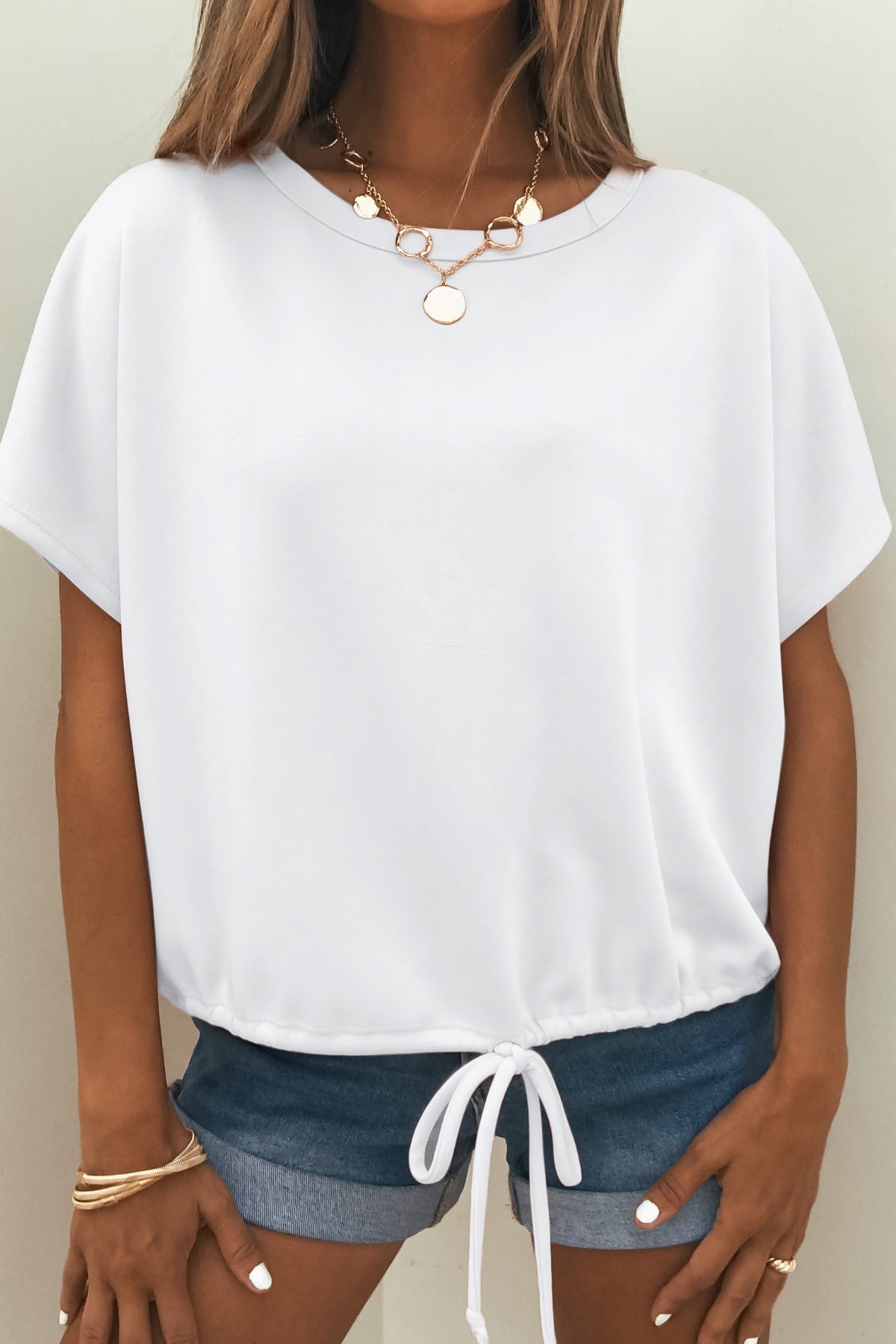 Woman wears the Soft Cloud Scuba Lounge Top - White with denim shorts, gold jewelry, and neutral nail polish.