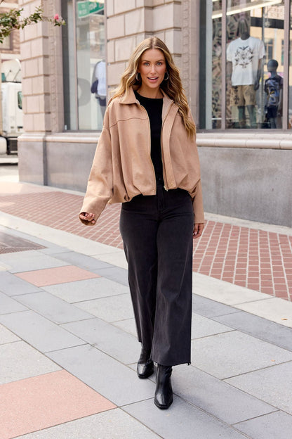 Woman in chic fall layers: Suede Bubble Hem Jacket - Camel, black top, wide-leg pants, and black boots on a city sidewalk.