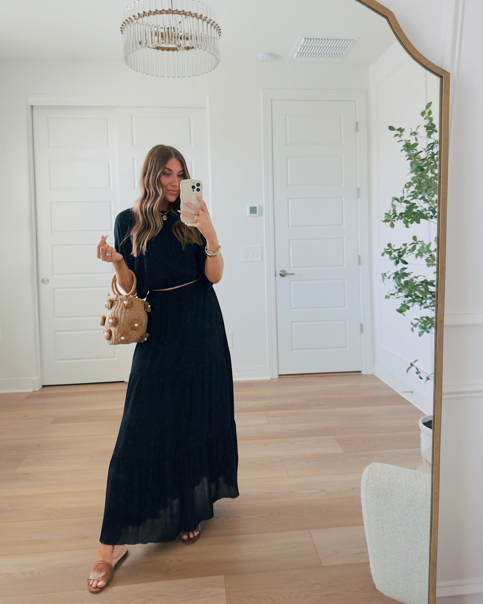 Woman takes a mirror selfie in a bright room, wearing the Sunrise Short Sleeve Top & Maxi Skirt Black Set - FINAL SALE.