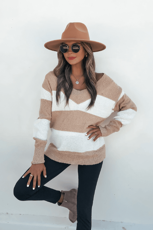 Woman in a Magnolia Tan and Ivory Striped Sweater, black pants, and ankle boots poses confidently with one hand on her hip.