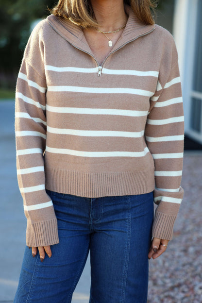 Woman in a Taupe and Cream Striped Quarter Zip Pullover - FINAL SALE, paired with blue jeans, standing outdoors hands by her sides.