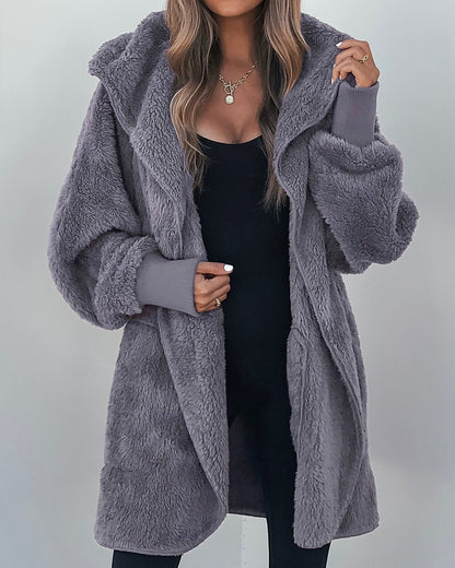 Woman in a Teddy Fleece Hooded Cardigan, plush gray and long, styled over black with wavy hair and layered necklaces.