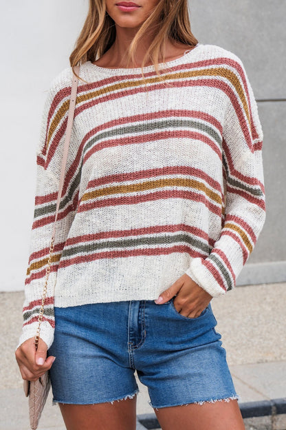 A woman styles The Reeves Striped Sweater - Red with denim shorts and a crossbody bag for a casual, colorful look.