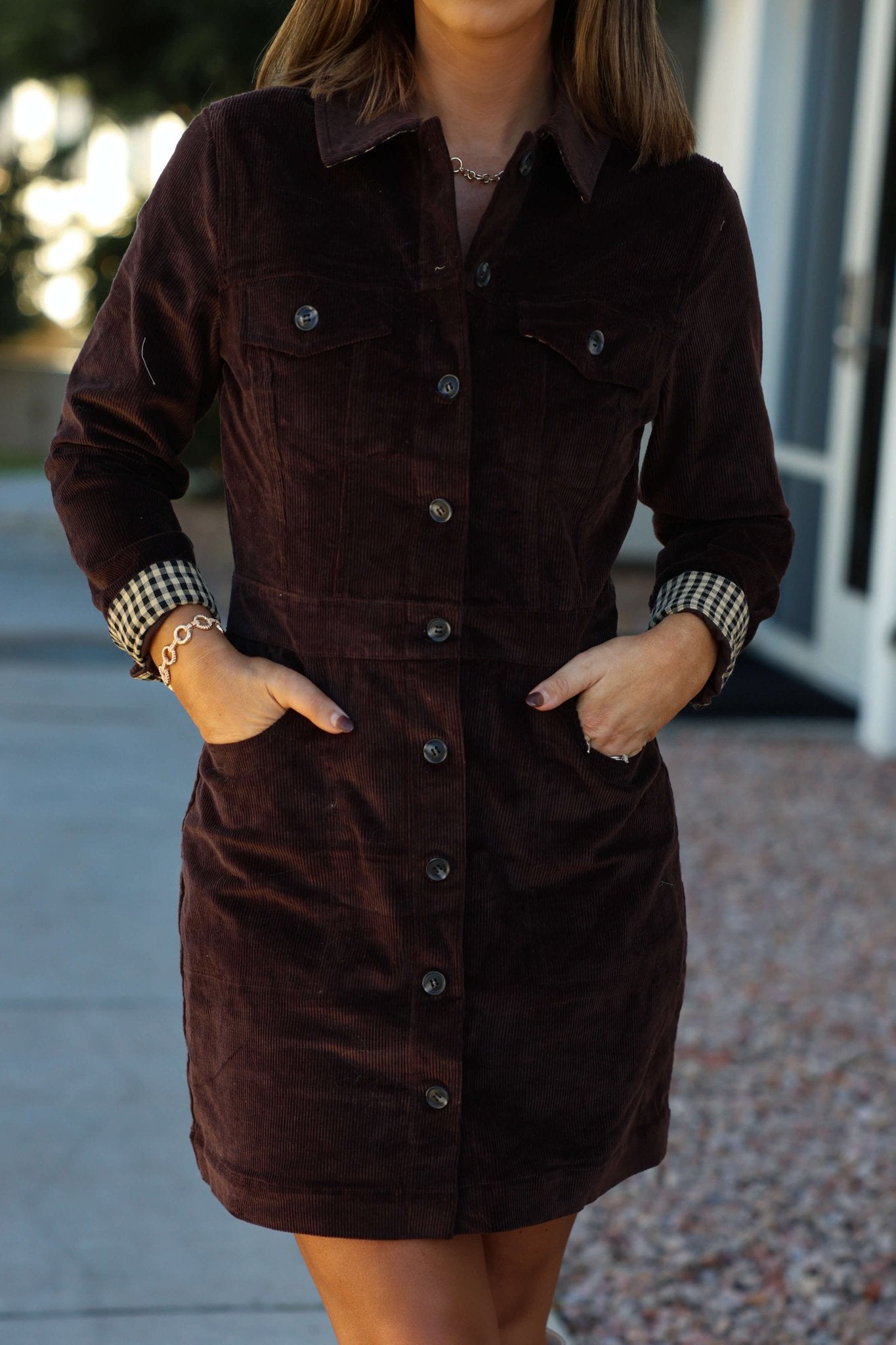 Woman wearing the Thread and Supply Brown Corduroy Mini Dress with front pockets, standing outdoors with hands in pockets.
