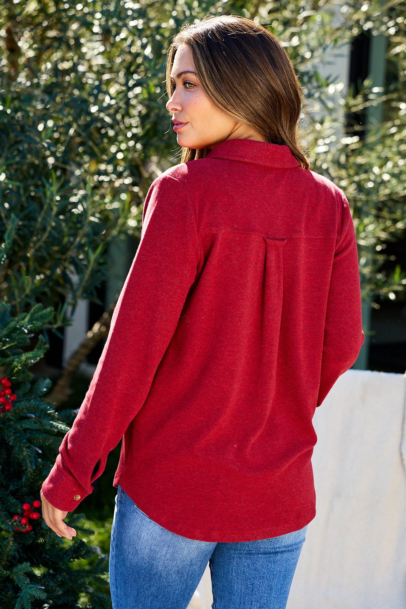 Woman wears the Thread and Supply Crimson Brushed Button Down Shirt—ultra-soft fabric—outdoors, facing away from the camera.