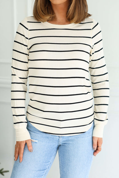 A woman wears the Thread and Supply Ivory Striped Top with light blue jeans, set against a white background.