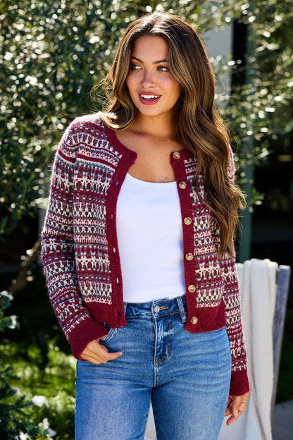 Woman wearing a Wine Fair Isle Button Down Cardigan, white tank top, and blue jeans, smiling outdoors.