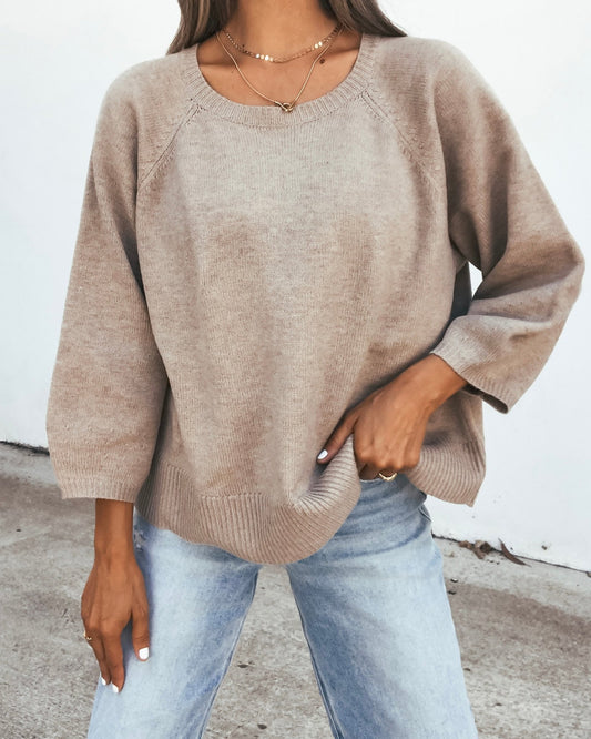 A person wearing a 3/4 Sleeve Sweater - Taupe and light-wash jeans.