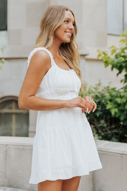 Woman in a Square Neck White Gathered Tiered Dress - FINAL SALE, outdoors smiling with long blonde hair.